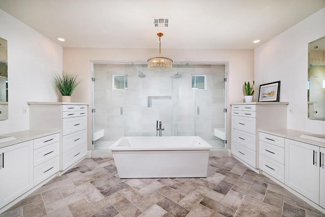 bathroom with separate shower and tub, vanity, and a chandelier