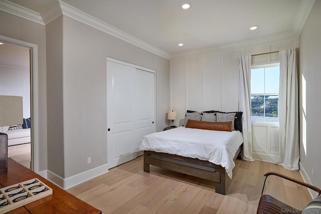 bedroom with a closet, crown molding, and light hardwood / wood-style floors