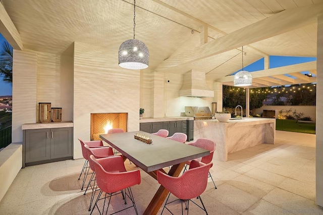 dining area with sink and vaulted ceiling with beams