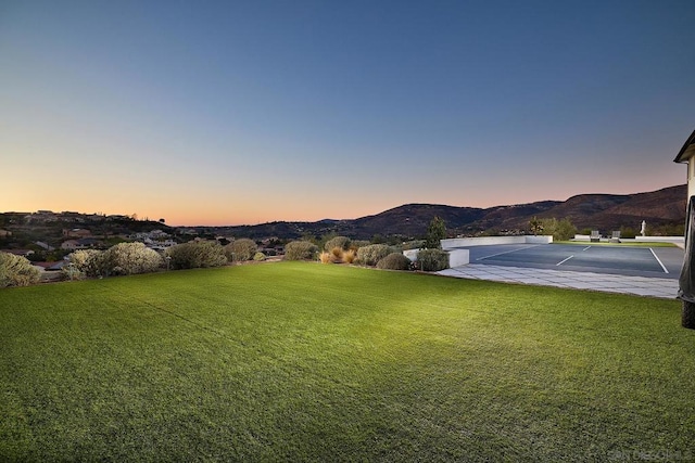 yard at dusk featuring a mountain view