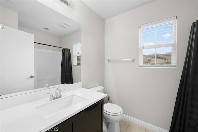 bathroom featuring plenty of natural light, toilet, tile patterned flooring, and vanity