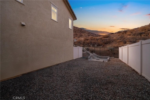 yard at dusk featuring a mountain view