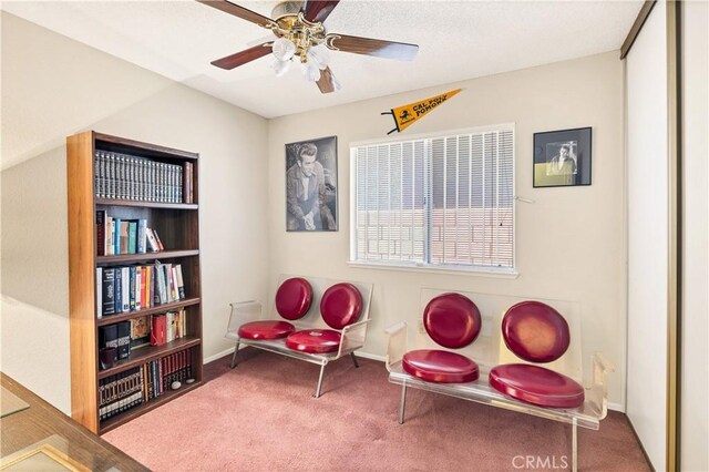 living area featuring carpet flooring and ceiling fan