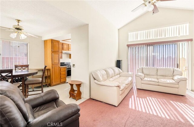 living room featuring ceiling fan, vaulted ceiling, and light carpet