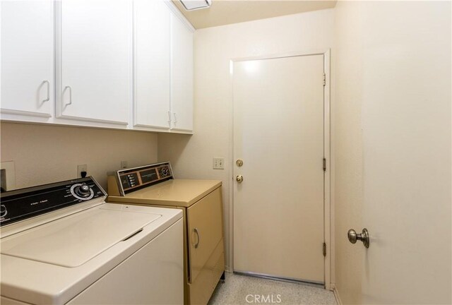 laundry area with separate washer and dryer and cabinets