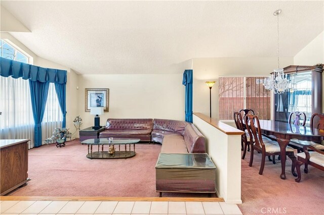 carpeted living room with vaulted ceiling and a chandelier