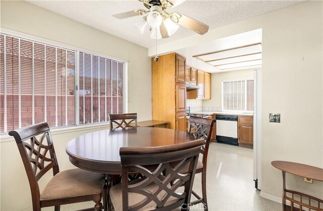 dining area featuring ceiling fan and a textured ceiling