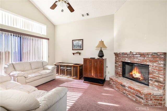 living room with a brick fireplace, carpet floors, ceiling fan, and vaulted ceiling