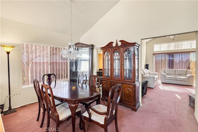 dining area featuring high vaulted ceiling, carpet flooring, and a notable chandelier