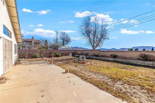 view of yard featuring a patio and a mountain view