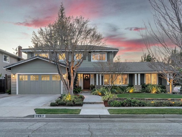 front of property with a garage and a yard