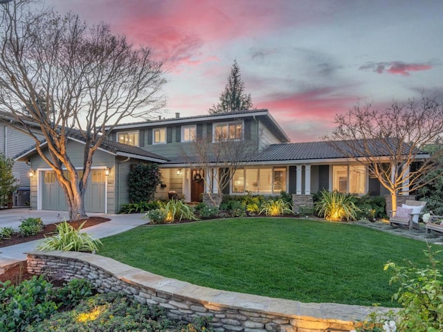 view of front of property featuring a lawn and a garage