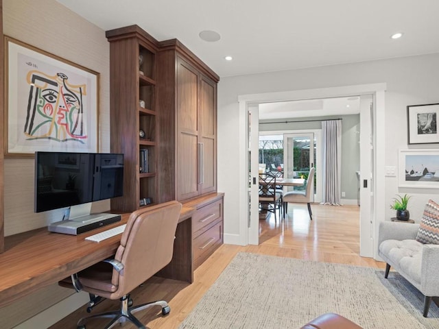 office area featuring built in desk and light hardwood / wood-style flooring