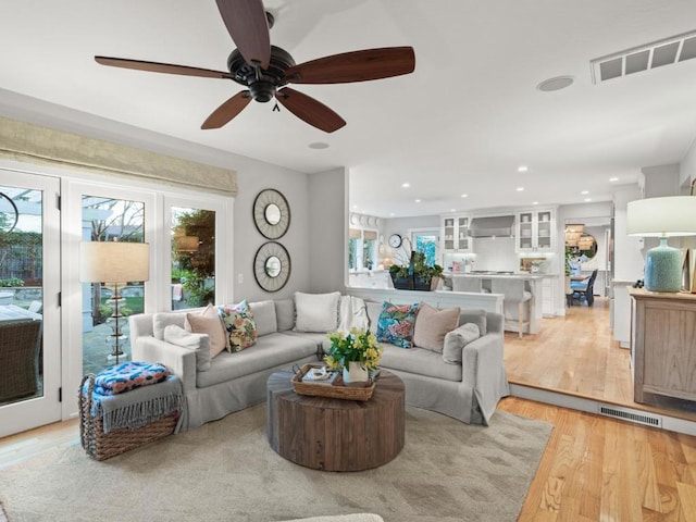 living room featuring ceiling fan and light hardwood / wood-style flooring