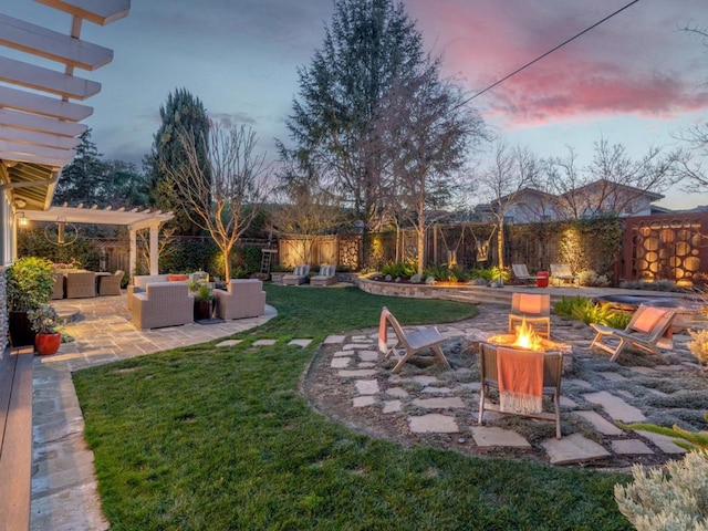 yard at dusk featuring a patio area, an outdoor living space with a fire pit, and a pergola