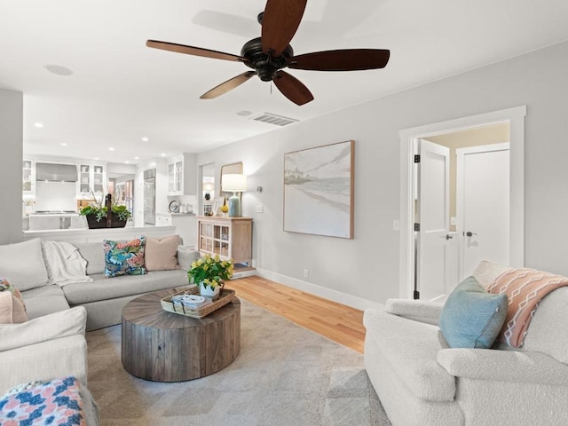 living room featuring ceiling fan and light hardwood / wood-style floors