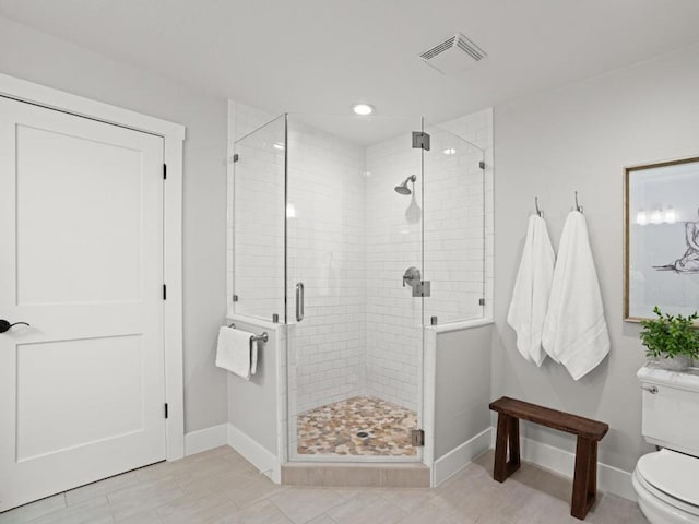 bathroom featuring toilet, tile patterned flooring, and an enclosed shower