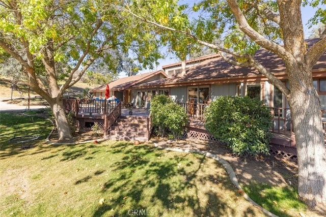 rear view of house with a deck and a yard