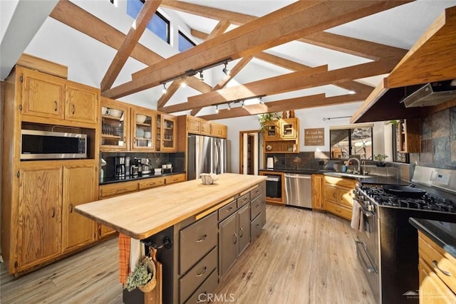 kitchen with backsplash, a center island, beam ceiling, sink, and stainless steel appliances