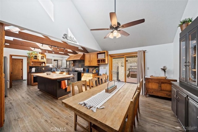 dining space with light hardwood / wood-style floors, high vaulted ceiling, and ceiling fan