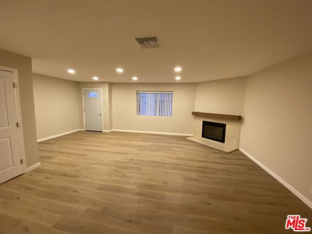 unfurnished living room featuring a fireplace and hardwood / wood-style floors