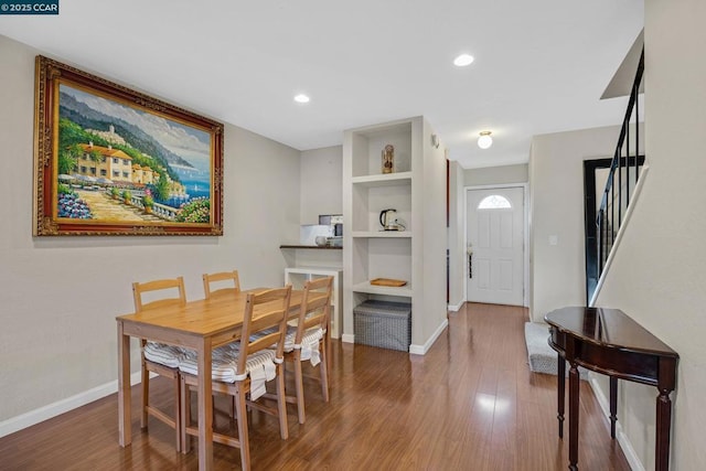 dining area featuring wood-type flooring and built in shelves