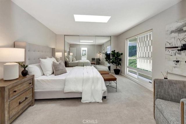 bedroom with a skylight and light carpet