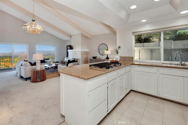 31146 Flying Cloud Dr, Laguna Niguel, CA 92677 - kitchen with a fireplace, white cabinets, light stone countertops, stainless steel gas stovetop, and a sink
