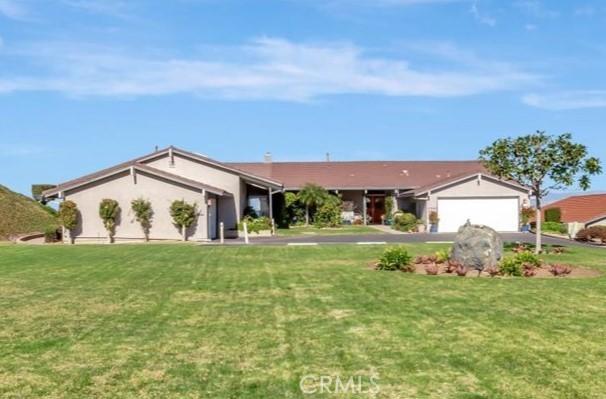 view of front facade featuring an attached garage, driveway, and a front lawn