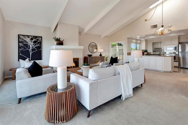 living area with light colored carpet, visible vents, high vaulted ceiling, a tile fireplace, and beamed ceiling