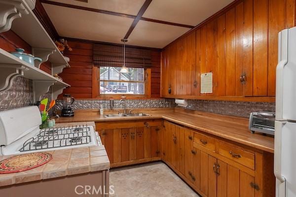 kitchen with range, white refrigerator, and sink