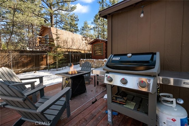 wooden terrace featuring a fire pit and area for grilling