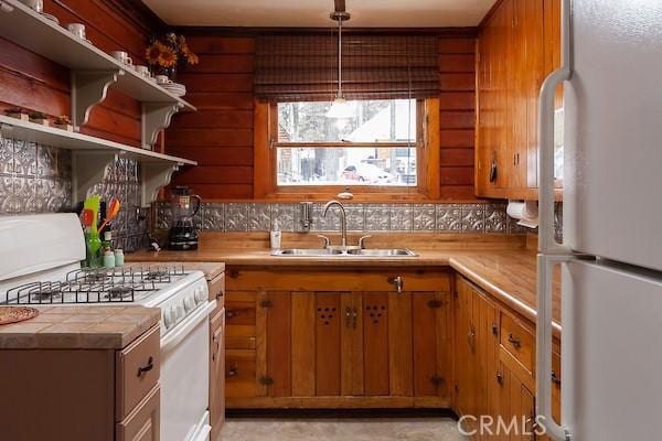 kitchen with white appliances, pendant lighting, tasteful backsplash, and sink