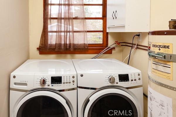 laundry area with washing machine and dryer and strapped water heater