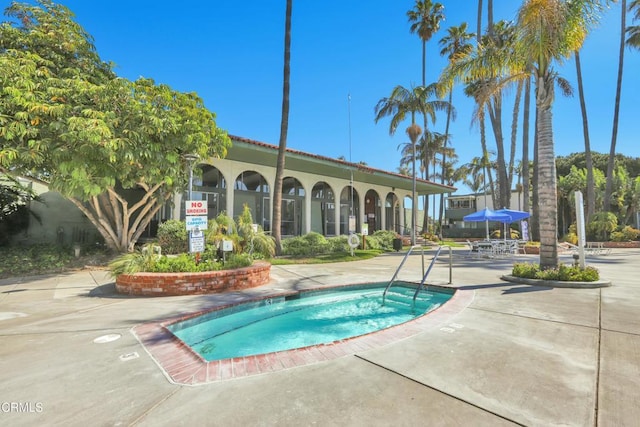 view of swimming pool featuring a hot tub