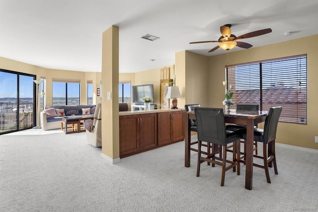 dining room with ceiling fan and light colored carpet