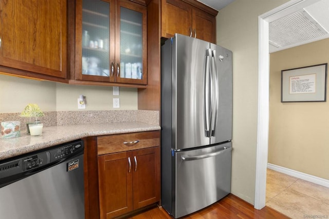 kitchen with light stone countertops and appliances with stainless steel finishes