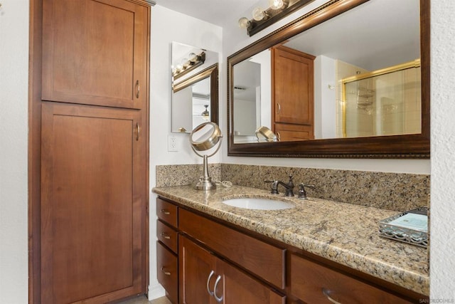 bathroom with vanity and a shower with door