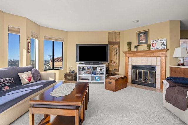 carpeted living room featuring a tiled fireplace