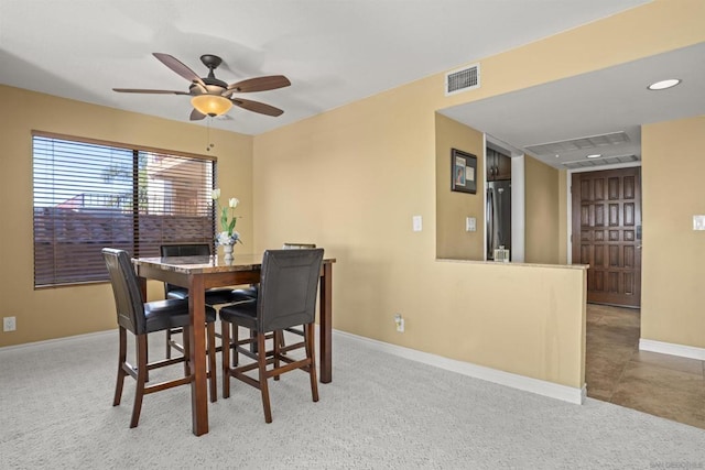 carpeted dining room with ceiling fan