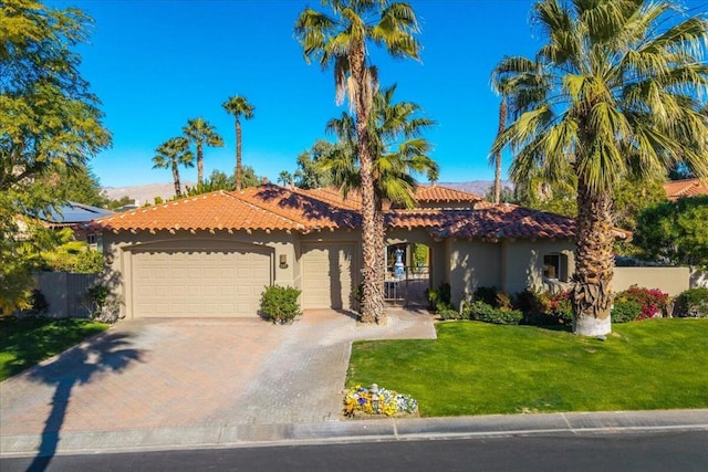 mediterranean / spanish-style home with a garage and a front lawn