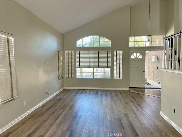 entrance foyer with hardwood / wood-style floors and high vaulted ceiling