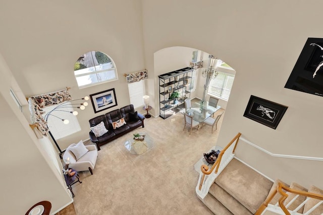 carpeted living room featuring a high ceiling