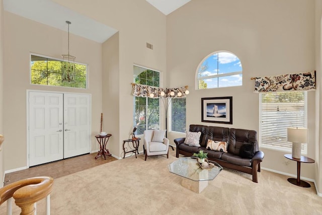 carpeted living room featuring a towering ceiling