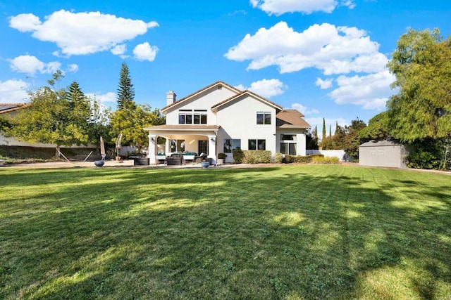 rear view of house featuring a patio, outdoor lounge area, a shed, and a lawn