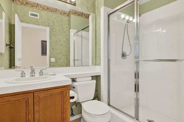 bathroom featuring vanity, an enclosed shower, and toilet