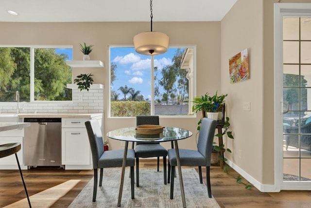 dining room with sink, dark wood-type flooring, and a healthy amount of sunlight