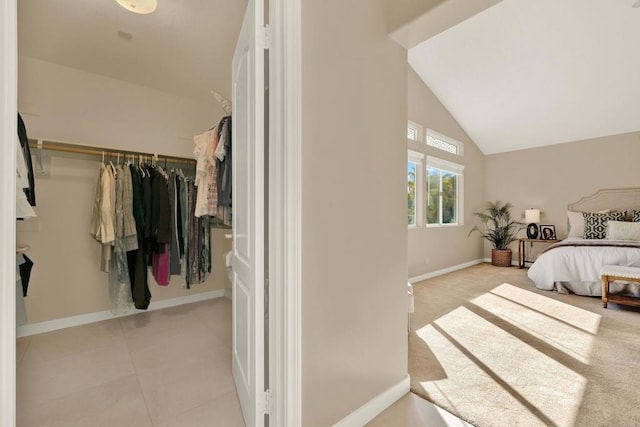 bedroom featuring light tile patterned floors, high vaulted ceiling, and a closet