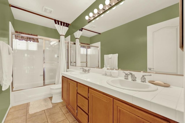 full bathroom featuring tile patterned flooring, enclosed tub / shower combo, vanity, and toilet