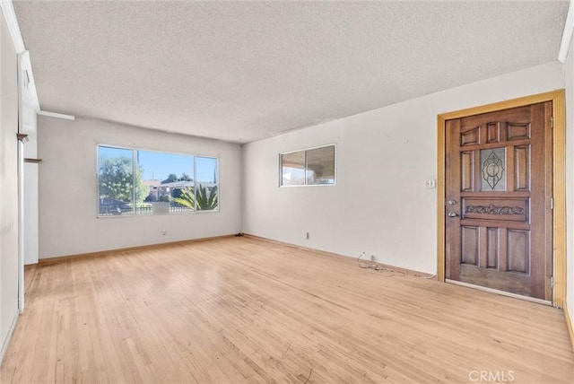 interior space featuring a textured ceiling and light hardwood / wood-style floors